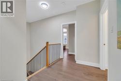Corridor featuring baseboards and wood finished floors - 