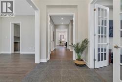 Hallway featuring dark wood-style flooring, french doors, and recessed lighting - 