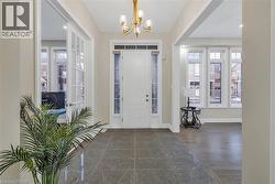 Entryway featuring plenty of natural light, dark wood-type flooring, and a chandelier - 