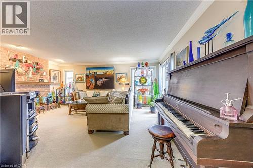 Living area with ornamental molding, light carpet, and a textured ceiling - 4220 Millcroft Park Drive, Burlington, ON - Indoor