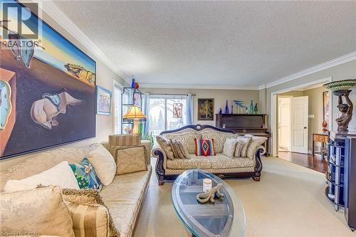 Carpeted living area with crown molding and a textured ceiling - 4220 Millcroft Park Drive, Burlington, ON - Indoor Photo Showing Living Room