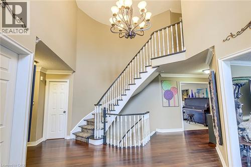 Stairway featuring ornamental molding, wood-type flooring, suspended lighting, and a high ceiling - 4220 Millcroft Park Drive, Burlington, ON - Indoor Photo Showing Other Room