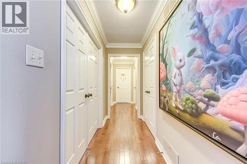 Hallway featuring a textured ceiling, crown molding, and light wood-style floors - 4220 Millcroft Park Drive, Burlington, ON - Indoor Photo Showing Other Room