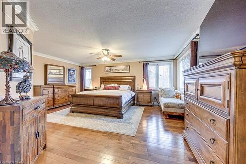Bedroom with crown molding, a textured ceiling, light wood-type flooring, and a ceiling fan - 4220 Millcroft Park Drive, Burlington, ON - Indoor Photo Showing Bedroom