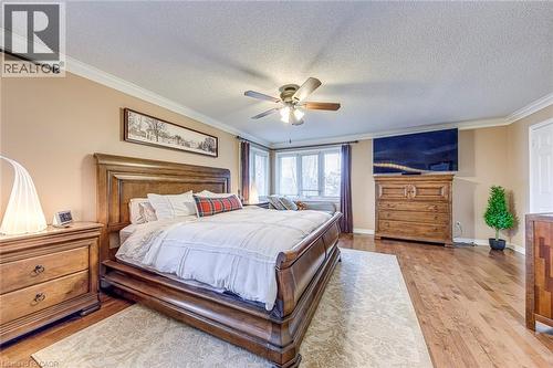 Bedroom with crown molding, a textured ceiling, ceiling fan, and light wood-style floors - 4220 Millcroft Park Drive, Burlington, ON - Indoor Photo Showing Bedroom
