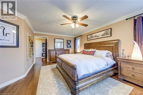 Bedroom featuring dark wood finished floors, ornamental molding, ceiling fan, and a textured ceiling - 4220 Millcroft Park Drive, Burlington, ON - Indoor Photo Showing Bedroom