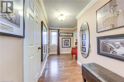 Corridor featuring crown molding, light wood-style floors, and a textured ceiling - 4220 Millcroft Park Drive, Burlington, ON - Indoor Photo Showing Other Room
