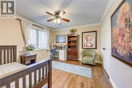 Bedroom featuring ornamental molding, light wood-style flooring, an office area, a textured ceiling, and ceiling fan - 4220 Millcroft Park Drive, Burlington, ON - Indoor Photo Showing Other Room