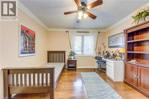Bedroom with light wood finished floors, a textured ceiling, a desk, a ceiling fan, and ornamental molding - 4220 Millcroft Park Drive, Burlington, ON - Indoor Photo Showing Bedroom
