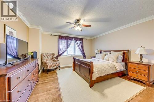 Bedroom featuring light wood-style floors, crown molding, ceiling fan, and a textured ceiling - 4220 Millcroft Park Drive, Burlington, ON - Indoor Photo Showing Bedroom