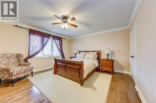 Bedroom with light wood-type flooring, crown molding, ceiling fan, and a textured ceiling - 4220 Millcroft Park Drive, Burlington, ON - Indoor Photo Showing Bedroom