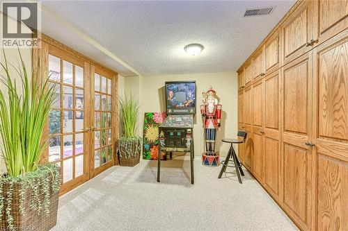 Recreation room with a textured ceiling, light carpet, and french doors - 4220 Millcroft Park Drive, Burlington, ON - Indoor Photo Showing Other Room