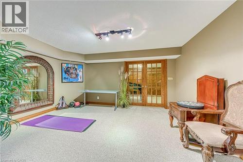 Workout area featuring french doors, rail lighting, carpet floors, a textured ceiling, and plenty of natural light - 4220 Millcroft Park Drive, Burlington, ON - Indoor