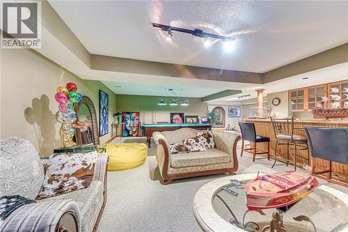 Carpeted living room with billiards, bar area, track lighting, and a textured ceiling - 4220 Millcroft Park Drive, Burlington, ON - Indoor