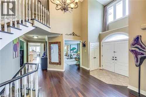 Foyer featuring dark wood-type flooring, a chandelier, a high ceiling, and crown molding - 4220 Millcroft Park Drive, Burlington, ON - Indoor Photo Showing Other Room