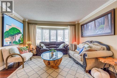 Living area with a textured ceiling, hardwood / wood-style floors, and ornamental molding - 4220 Millcroft Park Drive, Burlington, ON - Indoor Photo Showing Living Room