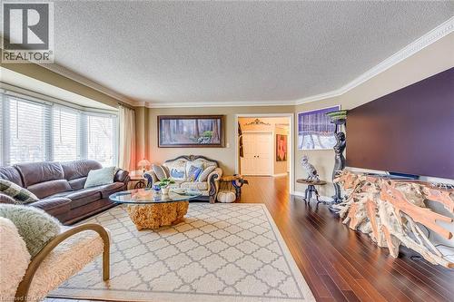 Living room with dark wood-style floors, a textured ceiling, and crown molding - 4220 Millcroft Park Drive, Burlington, ON - Indoor Photo Showing Living Room