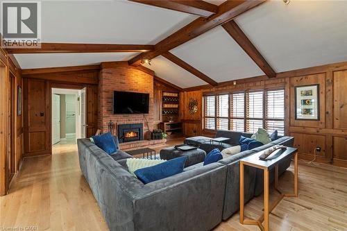 Living room with hardwood flooring, fireplace, cathedral ceiling and oak walls - 18 Stonegate Drive, Hamilton, ON - Indoor Photo Showing Living Room With Fireplace