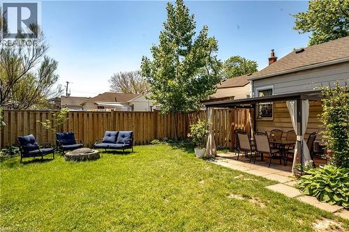 Expansive backyard featuring a manicured lawn, full privacy fencing, and mature trees - 364 Tragina Avenue N, Hamilton, ON - Outdoor