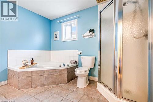 Full bathroom with a shower stall, a bath, and light tile patterned flooring - 65 Thistlemoor Drive, Caledonia, ON - Indoor Photo Showing Bathroom