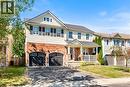 View of front of house featuring covered porch, driveway, an attached garage, and brick siding - 132 Blackburn Drive, Brantford, ON  - Outdoor With Deck Patio Veranda With Facade 