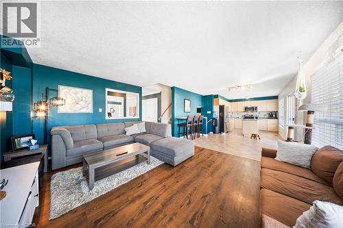 Living room featuring a textured ceiling and wood finished floors - 132 Blackburn Drive, Brantford, ON - Indoor Photo Showing Living Room