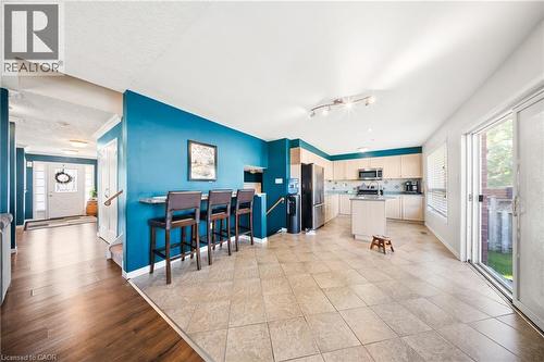 Kitchen with a center island, stainless steel appliances, light wood finished floors, open floor plan, and a textured ceiling - 132 Blackburn Drive, Brantford, ON - Indoor