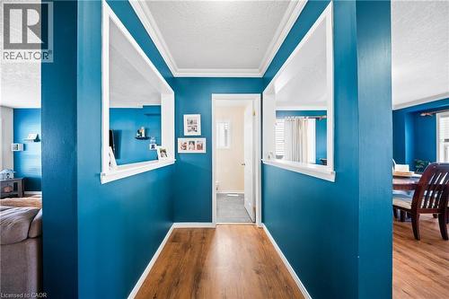 Hall featuring a textured ceiling, ornamental molding, wood finished floors, and plenty of natural light - 132 Blackburn Drive, Brantford, ON - Indoor Photo Showing Other Room