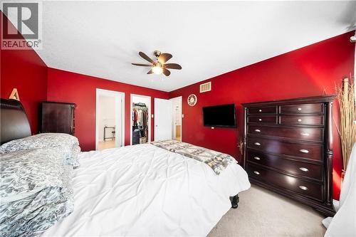 Bedroom featuring light carpet, ensuite bath, a ceiling fan, and a walk in closet - 132 Blackburn Drive, Brantford, ON - Indoor Photo Showing Bedroom