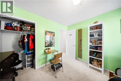 Carpeted bedroom featuring a desk and a closet - 132 Blackburn Drive, Brantford, ON - Indoor