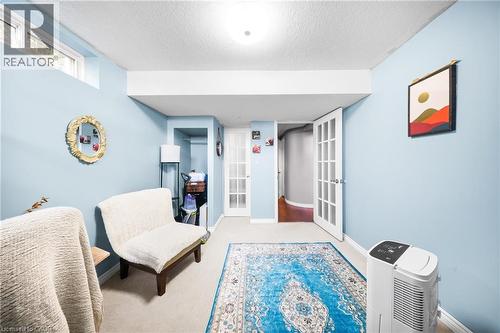 Living area with french doors, a textured ceiling, and carpet flooring - 132 Blackburn Drive, Brantford, ON - Indoor