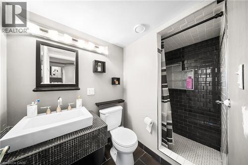 Bathroom with a stall shower and dark tile patterned floors - 132 Blackburn Drive, Brantford, ON - Indoor Photo Showing Bathroom