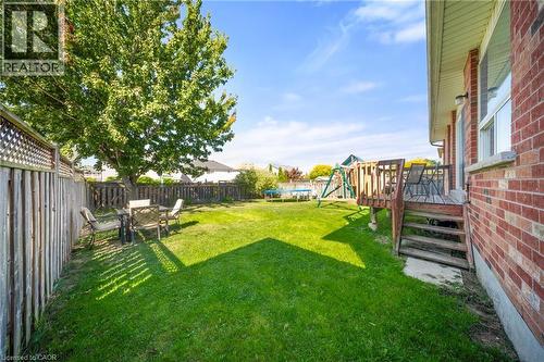 Fenced backyard featuring a trampoline, a deck, and a playground - 132 Blackburn Drive, Brantford, ON - Outdoor