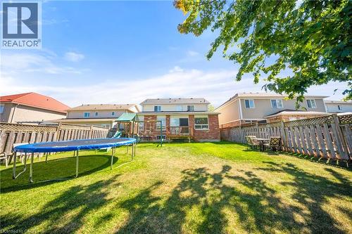 Fenced backyard featuring a trampoline - 132 Blackburn Drive, Brantford, ON - Outdoor With Backyard With Exterior