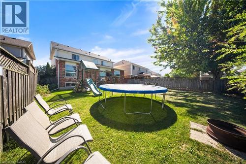 Fenced backyard featuring a playground and a trampoline - 132 Blackburn Drive, Brantford, ON - Outdoor With Backyard
