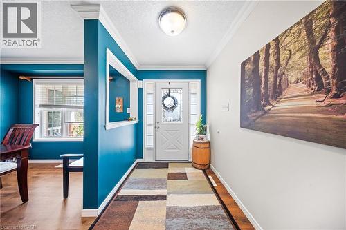 Entryway featuring ornamental molding, a textured ceiling, and light wood-type flooring - 132 Blackburn Drive, Brantford, ON - Indoor Photo Showing Other Room