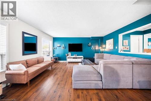 Living area featuring a textured ceiling and wood finished floors - 132 Blackburn Drive, Brantford, ON - Indoor Photo Showing Living Room