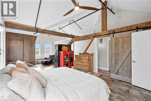 Bedroom with a barn door, wood finished floors, and ceiling fan - 25 Concession Street Unit# 201, Cambridge, ON - Indoor Photo Showing Bedroom