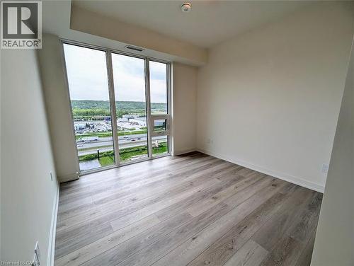 Spare room featuring light wood-style floors and expansive windows - 385 Winston Road Unit# 1311, Grimsby, ON - Indoor Photo Showing Other Room