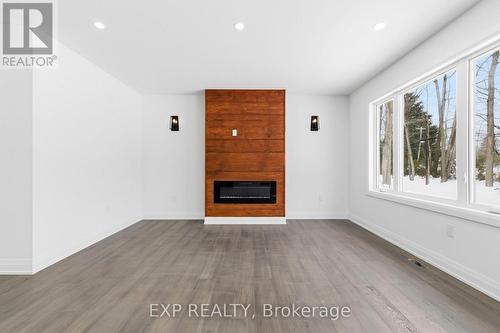 Living room view w/ pine feature wall & fireplace - 49 Beaufort Crescent, Tiny, ON - Indoor With Fireplace