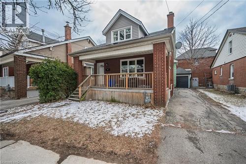 Bungalow-style home with covered porch, an outbuilding, a chimney, a garage, and brick siding - 43 Sterling Street, Hamilton, ON - Outdoor