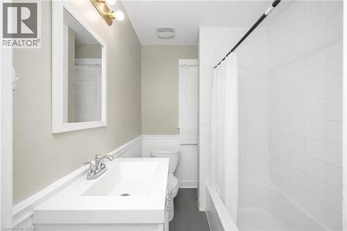 Bathroom with vanity, shower / bathtub combination with curtain, and dark tile patterned floors - 43 Sterling Street, Hamilton, ON - Indoor Photo Showing Bathroom
