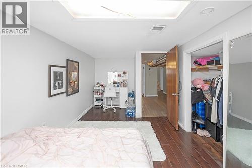 Bedroom with dark wood-style flooring, a desk, and a closet - 43 Sterling Street, Hamilton, ON - Indoor Photo Showing Bedroom