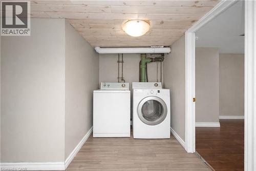 Laundry area featuring wood finished floors, separate washer and dryer, and wood ceiling - 43 Sterling Street, Hamilton, ON - Indoor Photo Showing Laundry Room