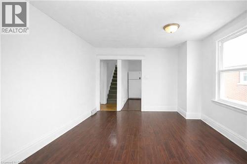 Empty room featuring dark wood-type flooring and baseboards - 43 Sterling Street, Hamilton, ON - Indoor Photo Showing Other Room