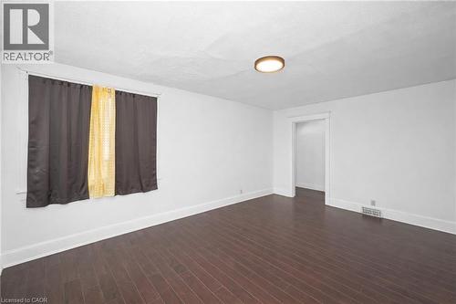 Empty room featuring baseboards and dark wood-type flooring - 43 Sterling Street, Hamilton, ON - Indoor Photo Showing Other Room