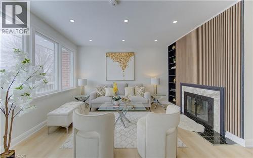 Living room with built in shelves, recessed lighting, a high end fireplace, and light wood-style floors - 171 Sixth Avenue, Kitchener, ON - Indoor Photo Showing Living Room With Fireplace