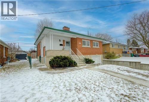 View of front of home with covered porch, brick siding, a chimney, and an attached garage - 171 Sixth Avenue, Kitchener, ON - Outdoor
