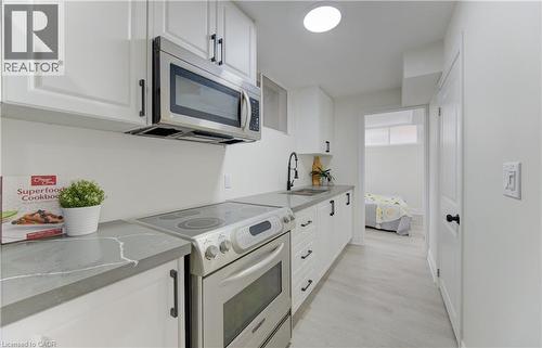 Kitchen featuring electric range oven, stainless steel microwave, and white cabinets - 171 Sixth Avenue, Kitchener, ON - Indoor Photo Showing Kitchen