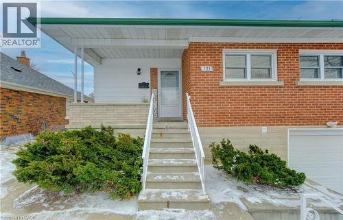 Entrance to property with brick siding, an attached garage, and a porch - 171 Sixth Avenue, Kitchener, ON - Outdoor With Exterior